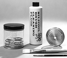 The Silicoil brush cleaning system: jar, fluid bottle and the coiled cleaning spiral
